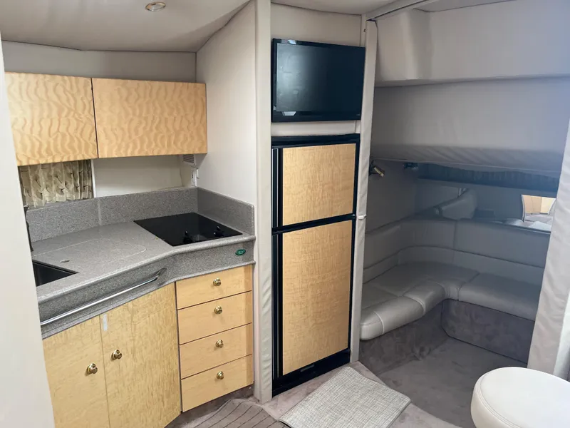 Slide: The Image of 1999 Formula 41 Performance Cruiser interior with kitchenette, fridge, and seating area. - 19