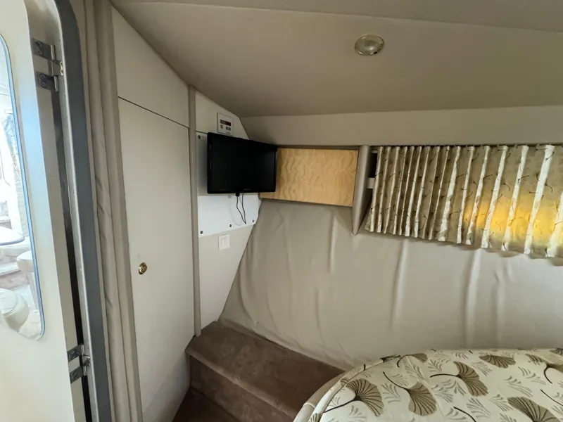 Slide: The Image of 1999 Formula 41 Performance Cruiser interior with TV, bed, and curtains. - 28