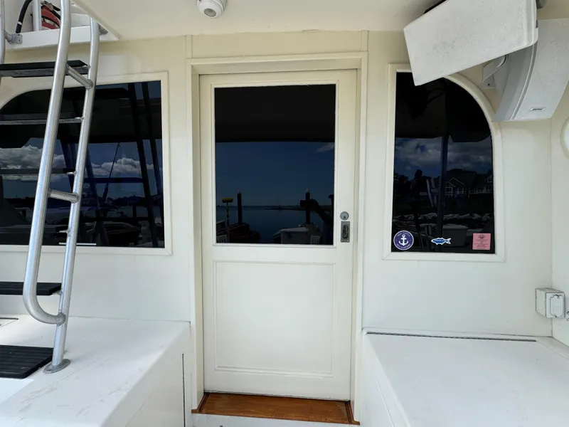 Slide: The Image of 1990 Post 44 Sport Fisherman boat exterior with ladder and door. - 13