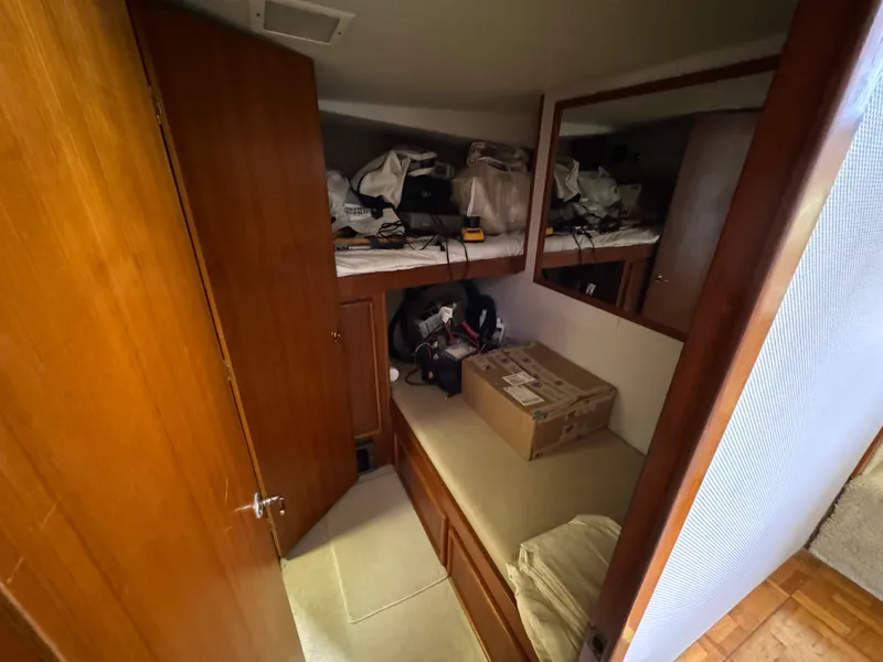 Slide: The Image of 1990 Post 44 Sport Fisherman cabin interior with storage and wooden finishes. - 21