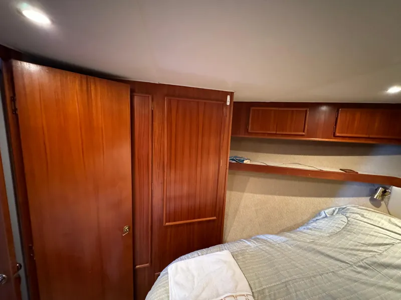 Slide: The Image of 1990 Post 44 Sport Fisherman cabin interior with wood paneling and bed. - 27