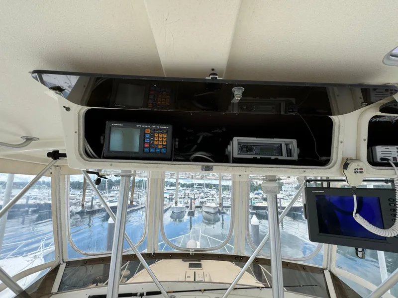Slide: The Image of 1990 Post 44 Sport Fisherman cockpit with navigation equipment and marina view. - 34