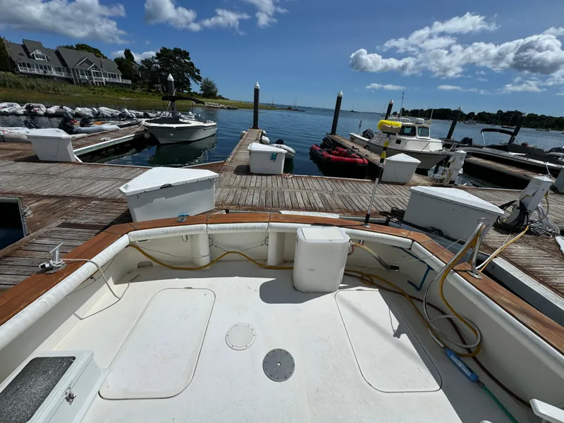 Slide: The Image of 1990 Post 44 Sport Fisherman docked at marina under blue sky. - 7