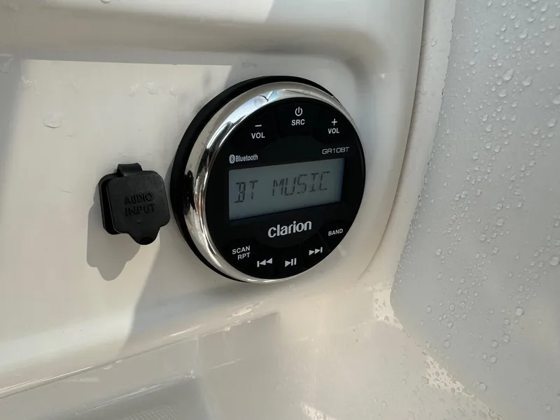 Slide: The Image of Clarion audio system on 2022 Robalo R207 Dual Console boat, displaying Bluetooth music. - 14