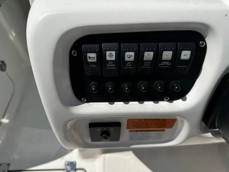 Slide: The Image of Control panel of 2022 Robalo R207 Dual Console boat with labeled switches. - 22