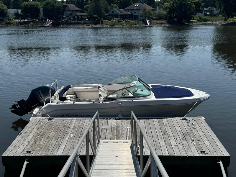Slide: The Image of 2022 Robalo R207 Dual Console boat docked on a serene lake. - 25
