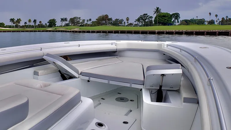 Slide: The Image of 2022 Yellowfin 42 Offshore boat interior with seating, near lush green shoreline. - 20