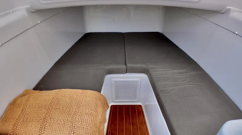 Slide: The Image of 2022 Yellowfin 42 Offshore cabin interior with cushioned seating and wooden flooring. - 24