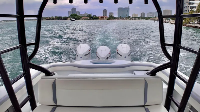 Slide: The Image of 2022 Yellowfin 42 Offshore boat cruising with triple engines, city skyline in background. - 6