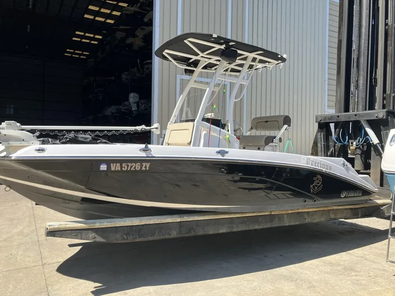 Slide: The Image of 2022 Yamaha Boats 190 FSH Sport in a boatyard, black hull, center console. - 0