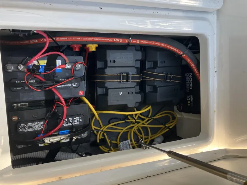 Slide: The Image of Battery compartment of 2022 Yamaha Boats 190 FSH Sport with wiring and connections. - 14