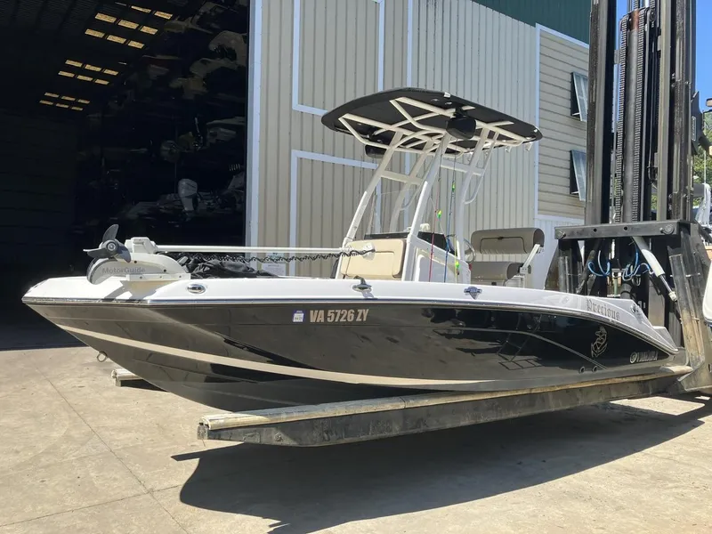Slide: The Image of 2022 Yamaha Boats 190 FSH Sport in storage, black hull, ready for adventure. - 4