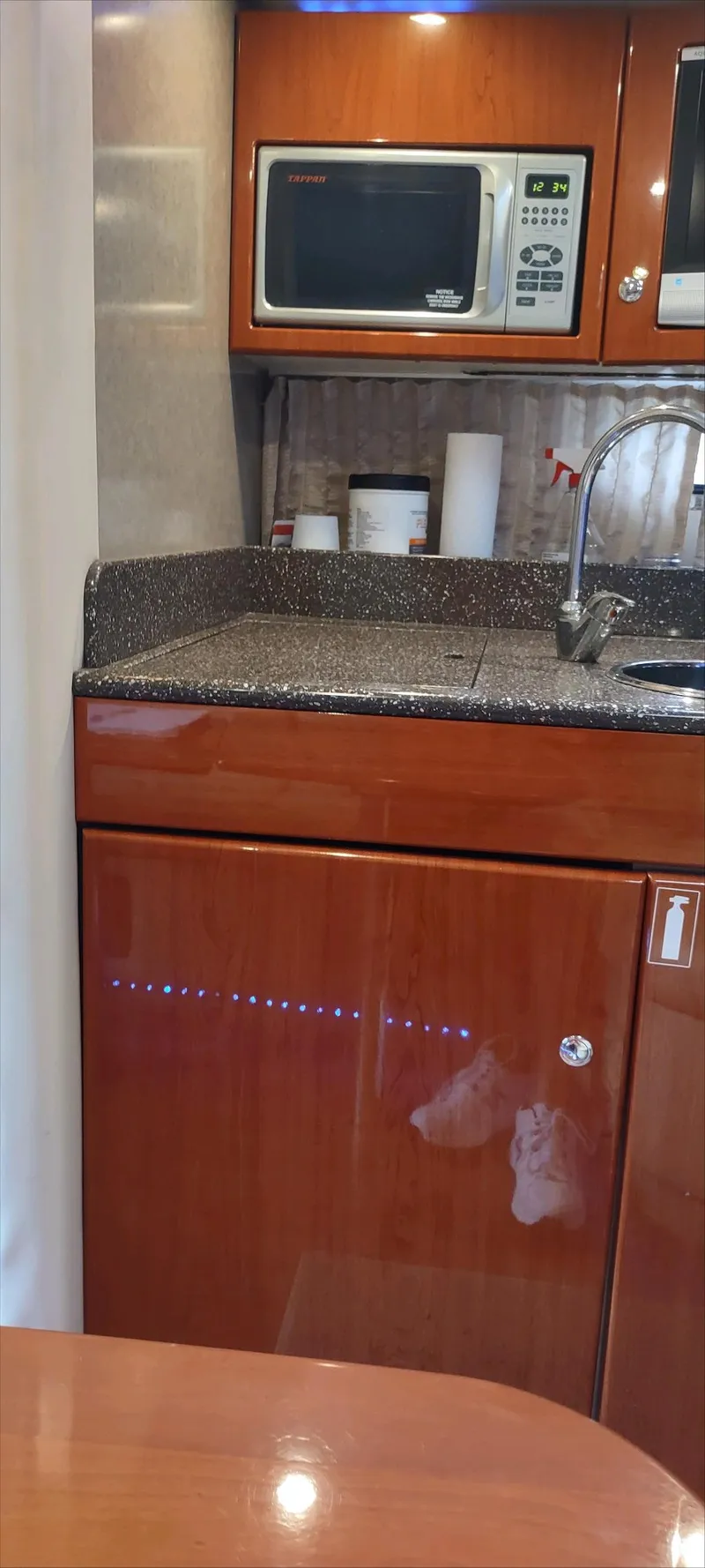 Slide: The Image of 2007 Formula 31 Cruiser kitchen area with microwave, sink, and wooden cabinetry. - 11