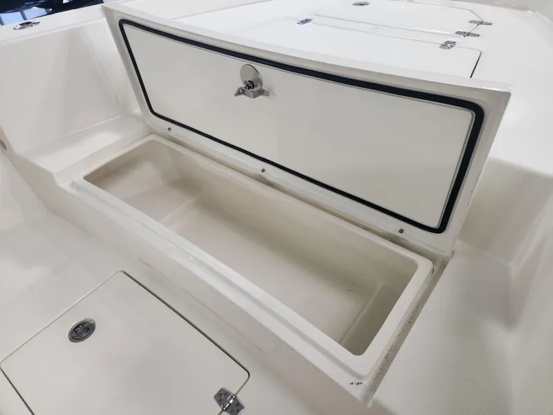 Slide: The Image of 2025 Pathfinder 2400 Open boat storage compartment, open lid, white interior. - 11