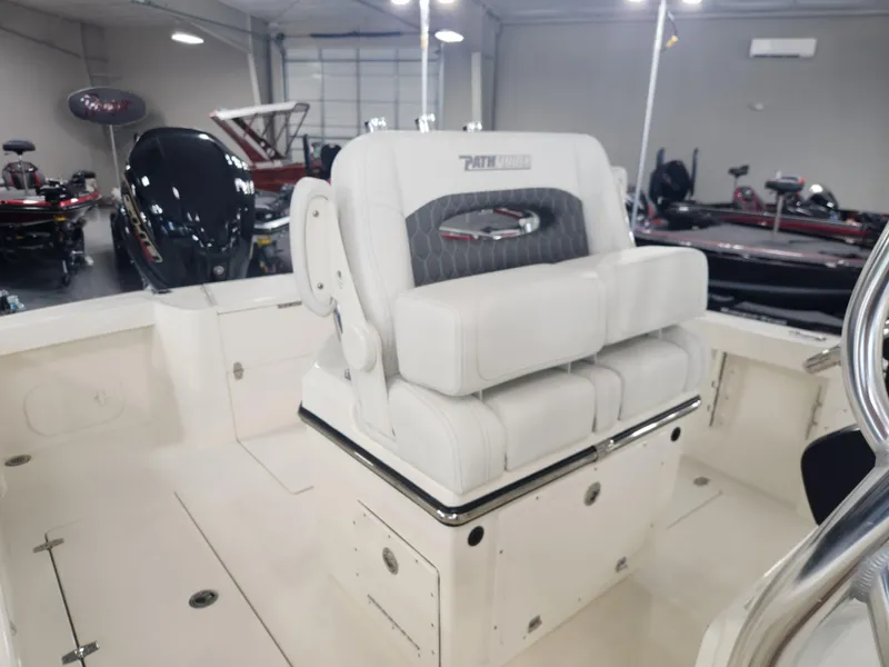 Slide: The Image of 2025 Pathfinder 2400 Open boat interior with cushioned seating in a showroom. - 23