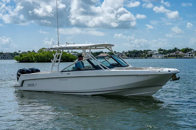 Slide: The Image of 2018 Boston Whaler 270 Vantage boat on calm water under a cloudy sky. - 16