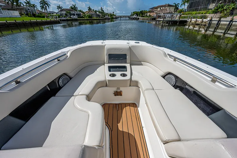 Slide: The Image of 2018 Boston Whaler 270 Vantage boat interior with cushioned seating and wooden deck. - 17