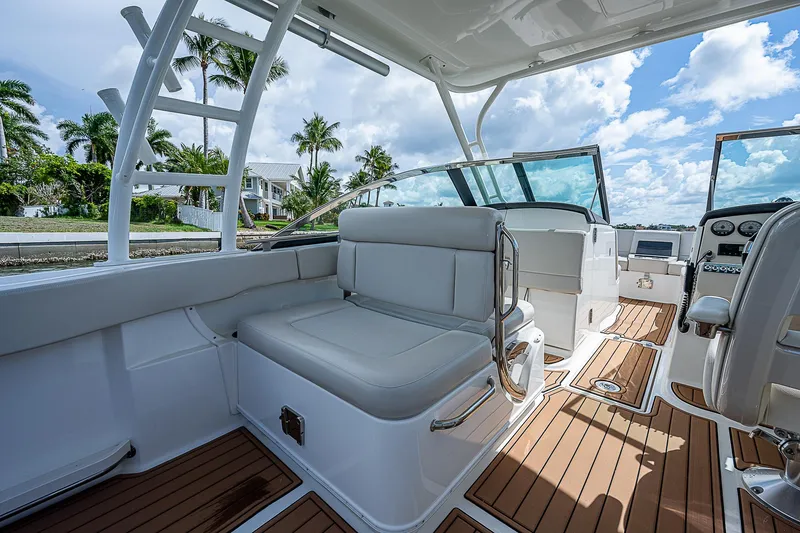 Slide: The Image of 2018 Boston Whaler 270 Vantage interior with seating, teak flooring, and clear skies. - 25
