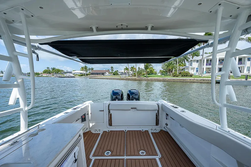 Slide: The Image of 2018 Boston Whaler 270 Vantage boat with dual engines, docked by waterfront homes. - 27