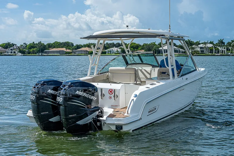 Slide: The Image of 2018 Boston Whaler 270 Vantage boat with twin Mercury engines on a calm lake. - 3