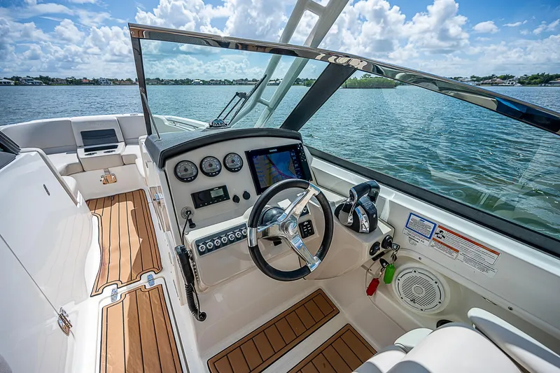 Slide: The Image of 2018 Boston Whaler 270 Vantage boat interior with steering wheel and dashboard, on a sunny day. - 34