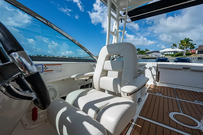 Slide: The Image of 2018 Boston Whaler 270 Vantage boat interior with white seating and wooden deck. - 36