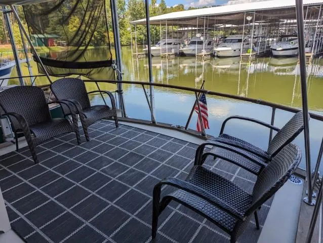 Slide: The Image of 1972 Chris-Craft 41 Commander deck with wicker chairs, overlooking marina with docked boats. - 12