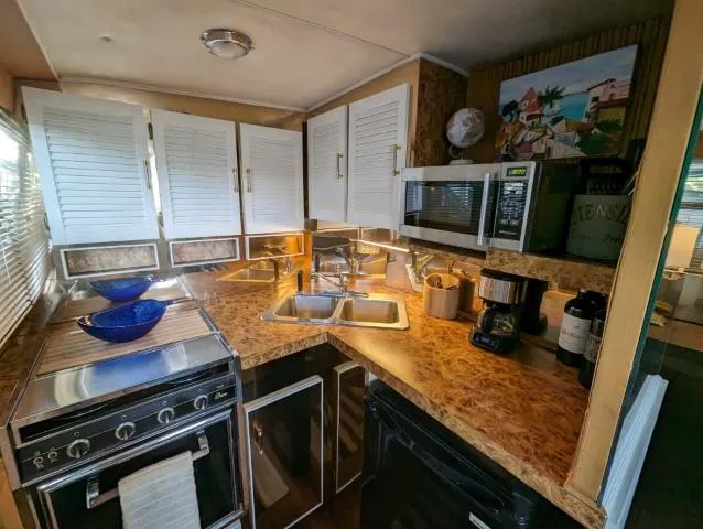 Slide: The Image of 1972 Chris-Craft 41 Commander kitchen with stove, microwave, and sink. Cozy and functional design. - 14