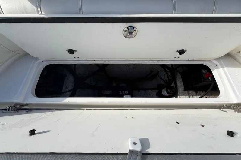 Slide: The Image of Open storage compartment on a 2021 Glasstream 280 SCX boat, showing interior components. - 100