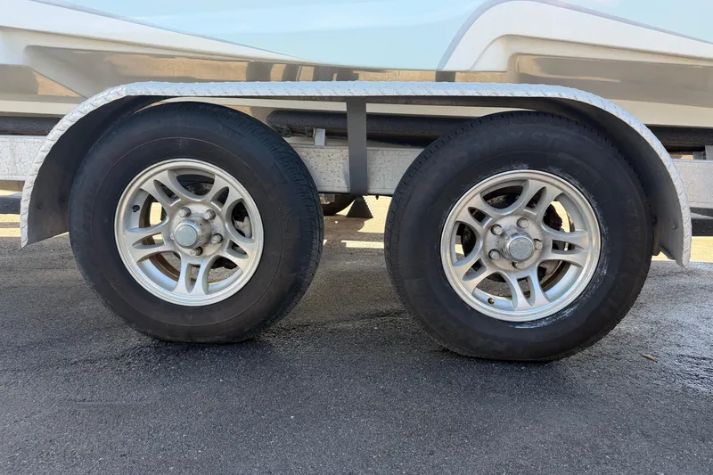 Slide: The Image of Trailer wheels of a 2021 Glasstream 280 SCX boat on pavement. - 108