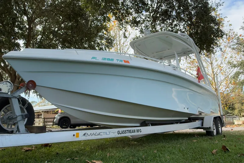 Slide: The Image of 2021 Glasstream 280 SCX boat with white cushioned seating under a blue sky. - 46