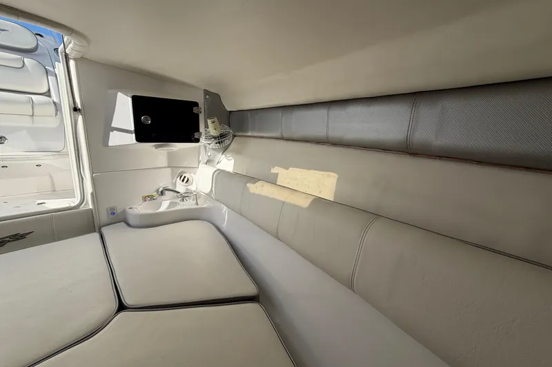 Slide: The Image of Interior of 2021 Glasstream 280 SCX boat, featuring cushioned seating and compact amenities. - 59