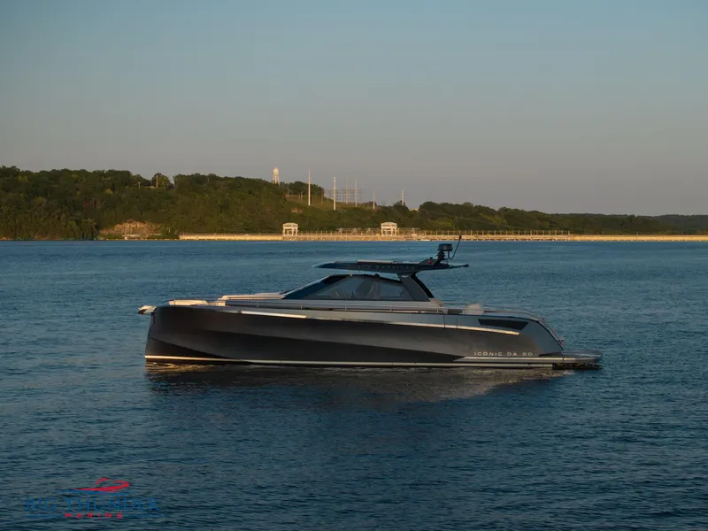 Slide: The Image of 2024 Dutch American Iconic DA 50 yacht on serene water with lush green shoreline. - 14