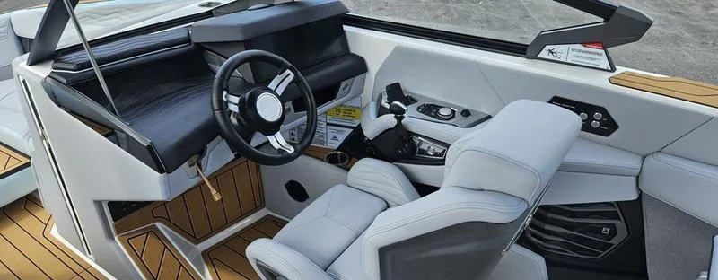 Slide: The Image of Interior of 2025 Nautique Super Air Nautique G23 boat, featuring modern helm and seating. - 13