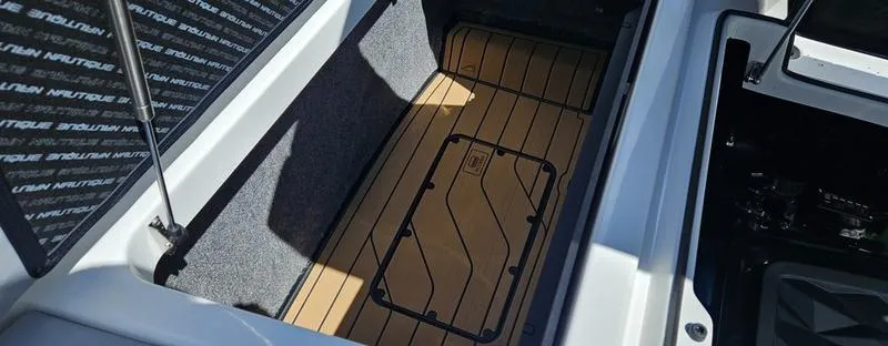 Slide: The Image of 2025 Nautique Super Air Nautique G23 storage compartment with teak flooring. - 35