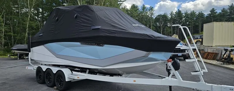 Slide: The Image of 2025 Nautique Super Air Nautique G23 boat covered on trailer, parked outdoors. - 38