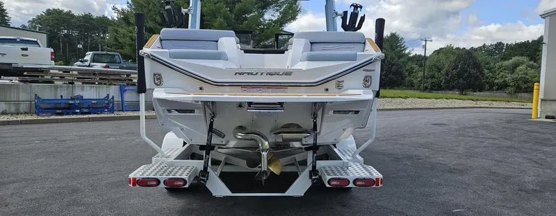 Slide: The Image of 2025 Nautique Super Air Nautique G23 boat rear view in a parking lot. - 5