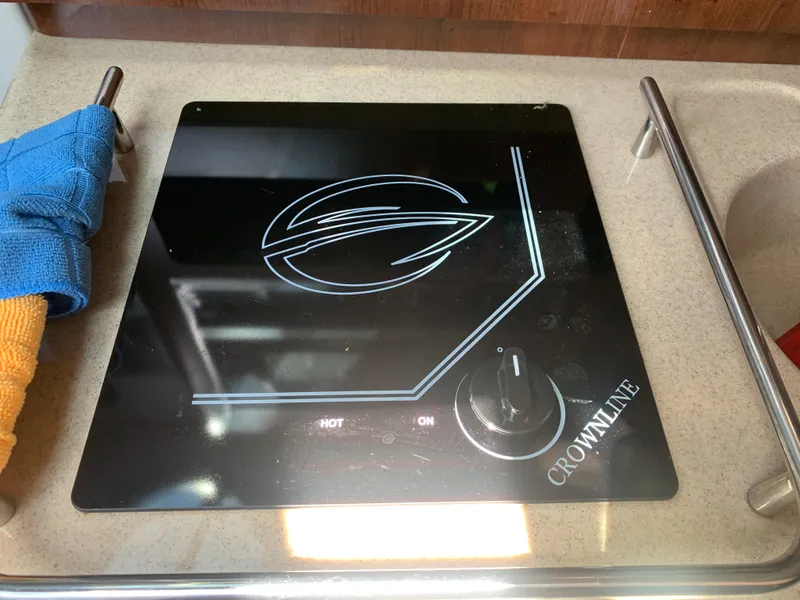 Slide: The Image of Crownline 264 CR 2018 boat stove with control knob and logo. - 26