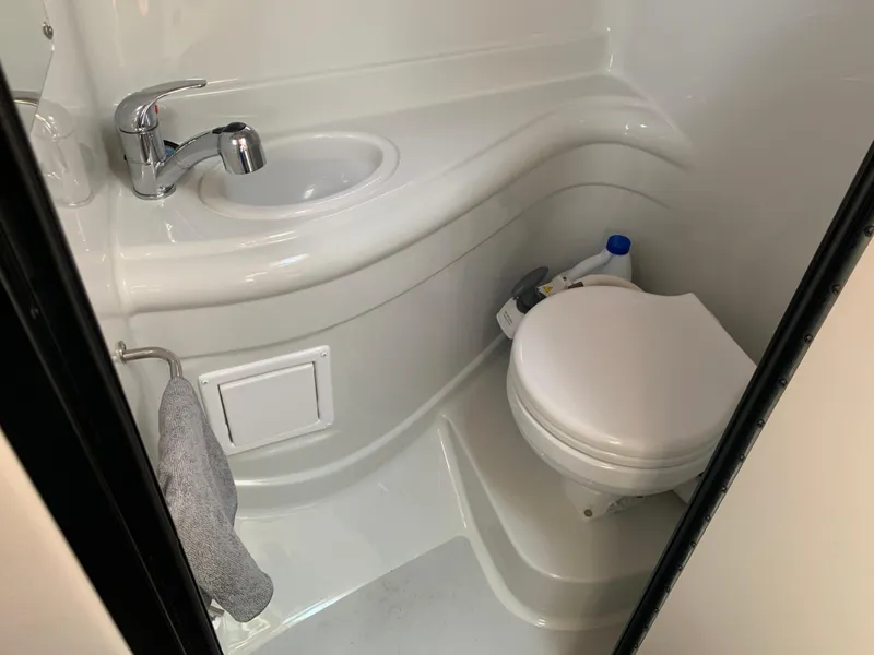 Slide: The Image of 2018 Crownline 264 CR boat bathroom with sink, toilet, and towel holder. - 30