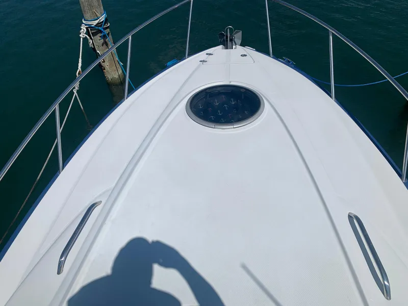 Slide: The Image of 2018 Crownline 264 CR boat deck with railing and hatch, docked on calm water. - 35