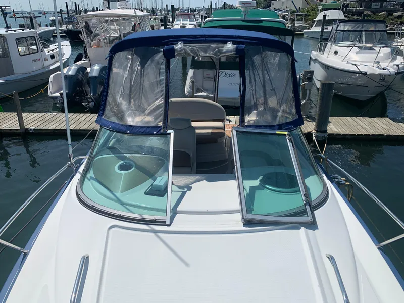Slide: The Image of 2018 Crownline 264 CR boat docked at marina, featuring open deck and clear canopy. - 38