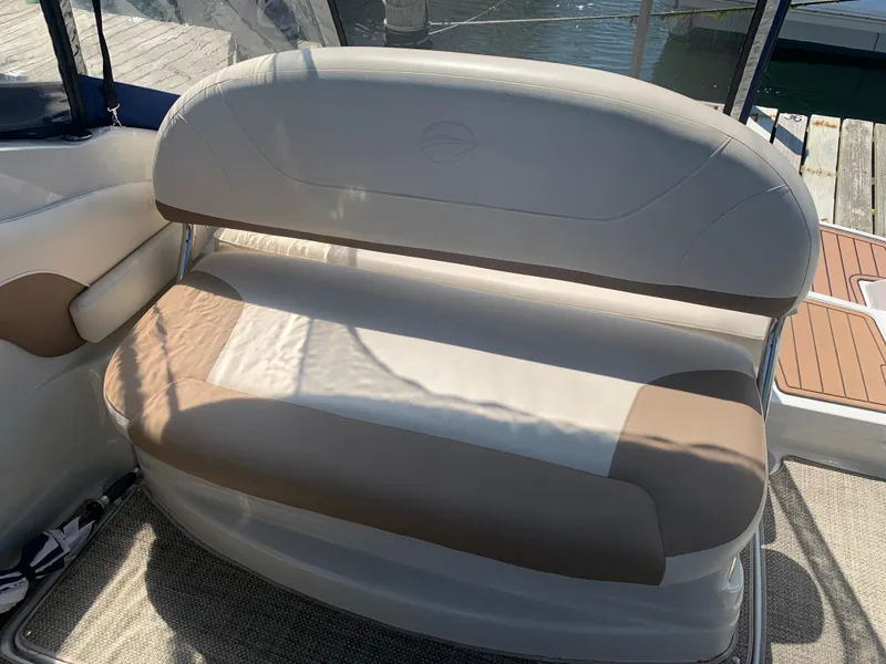 Slide: The Image of 2018 Crownline 264 CR boat seating with beige upholstery and dock view. - 40