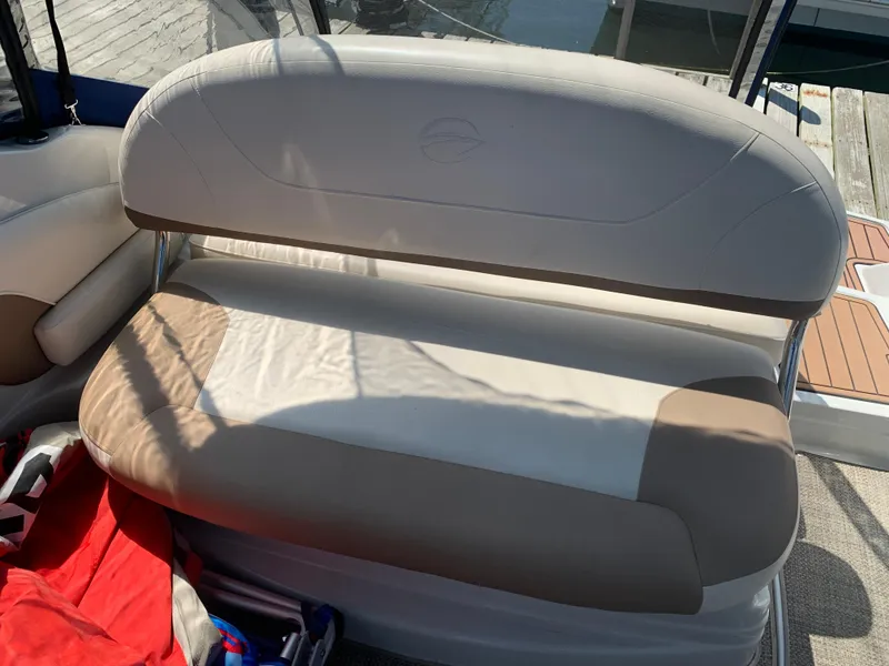 Slide: The Image of 2018 Crownline 264 CR boat seat with beige upholstery, dockside view. - 8