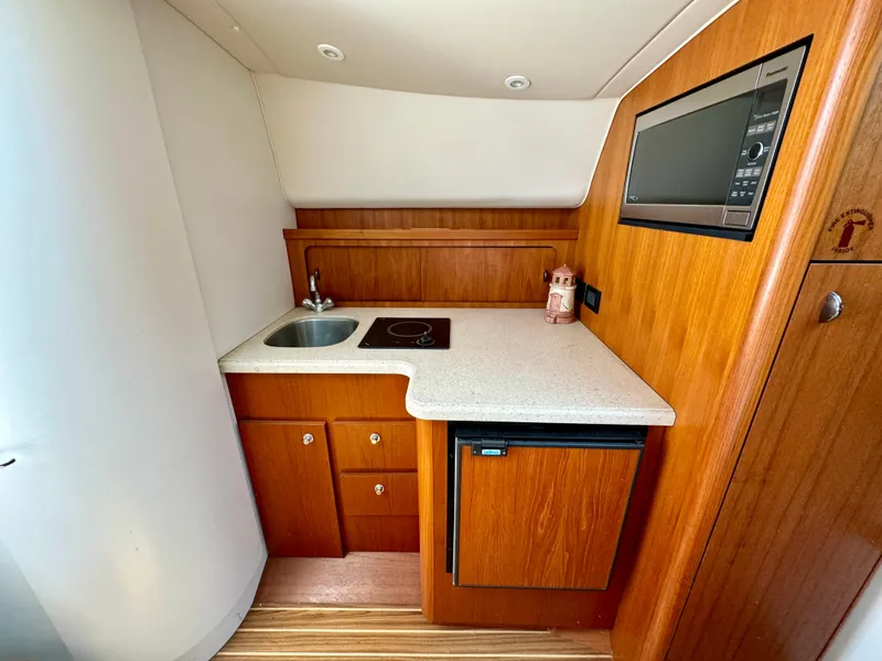 Slide: The Image of 2006 Tiara Yachts 29 Open galley with sink, stove, microwave, and fridge. - 10