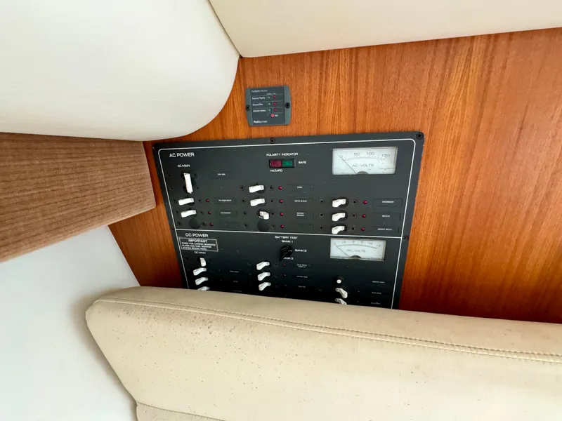 Slide: The Image of Control panel of a 2006 Tiara Yachts 29 Open, featuring AC and DC power switches. - 12