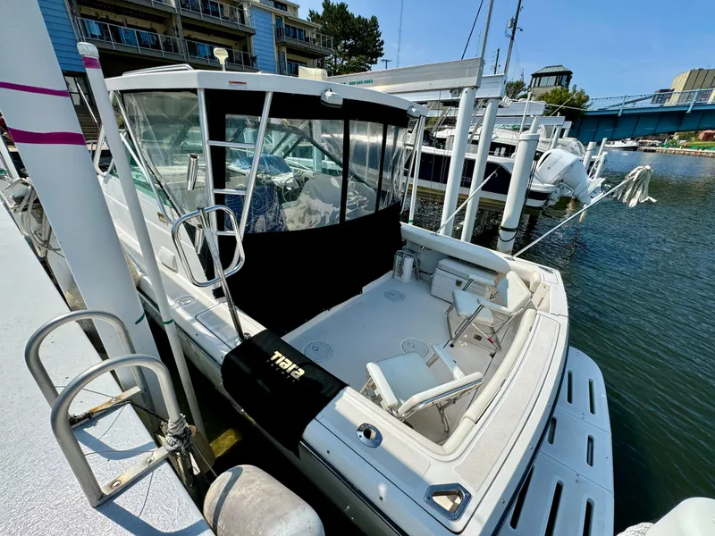 Slide: The Image of 2006 Tiara Yachts 29 Open docked at marina, featuring spacious deck and seating. - 2