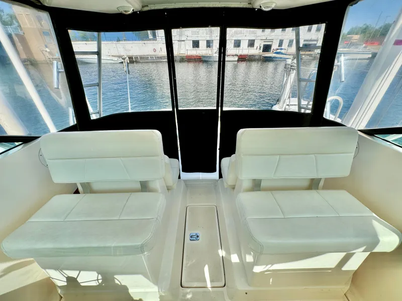 Slide: The Image of Interior of 2006 Tiara Yachts 29 Open with white seating and waterfront view. - 7