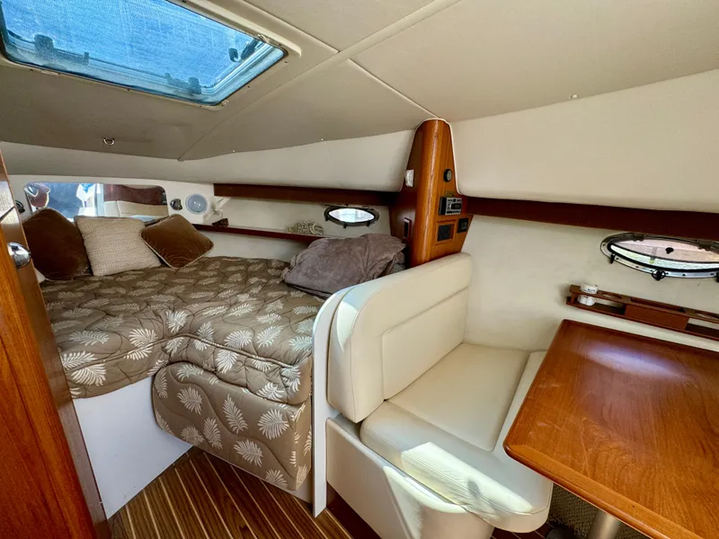 Slide: The Image of Interior of 2006 Tiara Yachts 29 Open, featuring cozy cabin with bed and seating area. - 8