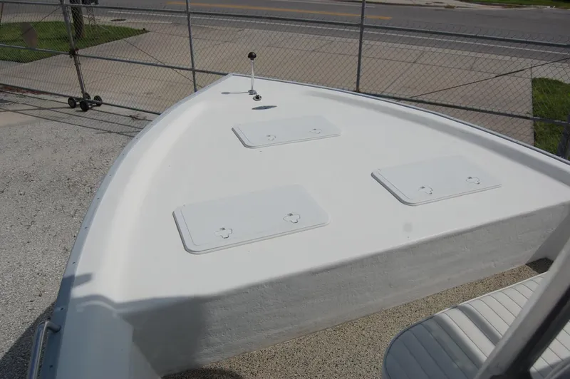 Slide: The Image of 2004 Cape Horn Cape Bay boat deck with storage hatches, parked near a fence. - 8