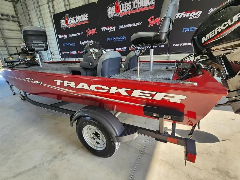 Slide: The Image of 2021 Tracker Pro 170 boat in showroom, red color, with Mercury engine. - 10